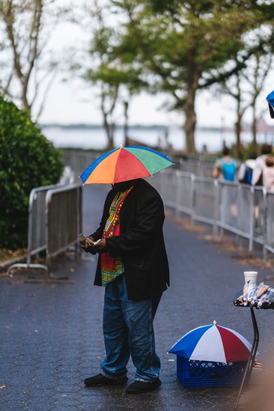 人与五彩缤纷的雨伞站在通路和其他人白天行走
